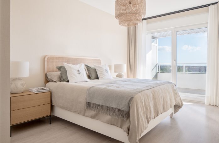 Proyecto Canela Dormitorio luminoso con cama doble, mesita de noche y ventana al exterior.